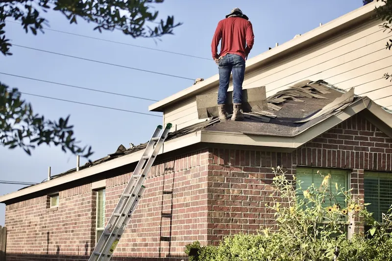 Professional roofer working on a residential roof in Free Acres